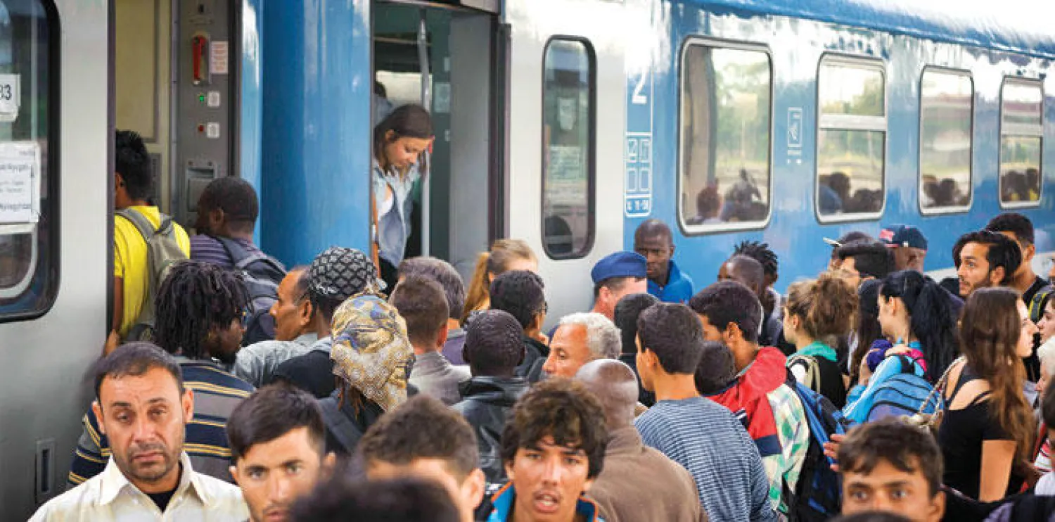 مهاجرون يتدافعون للصعود إلى قطار متجه إلى النمسا في محطة قطارات بالمجر أمس (أ.ب)  