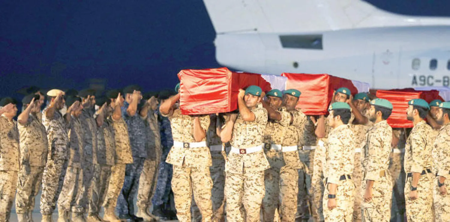 عناصر من القوات المسلحة البحرينية تحمل جثامين رفاقهم الذين «استشهدوا» في اليمن في قاعدة عيسى الجوية جنوب المنامة  أمس (ا.ف.ب)