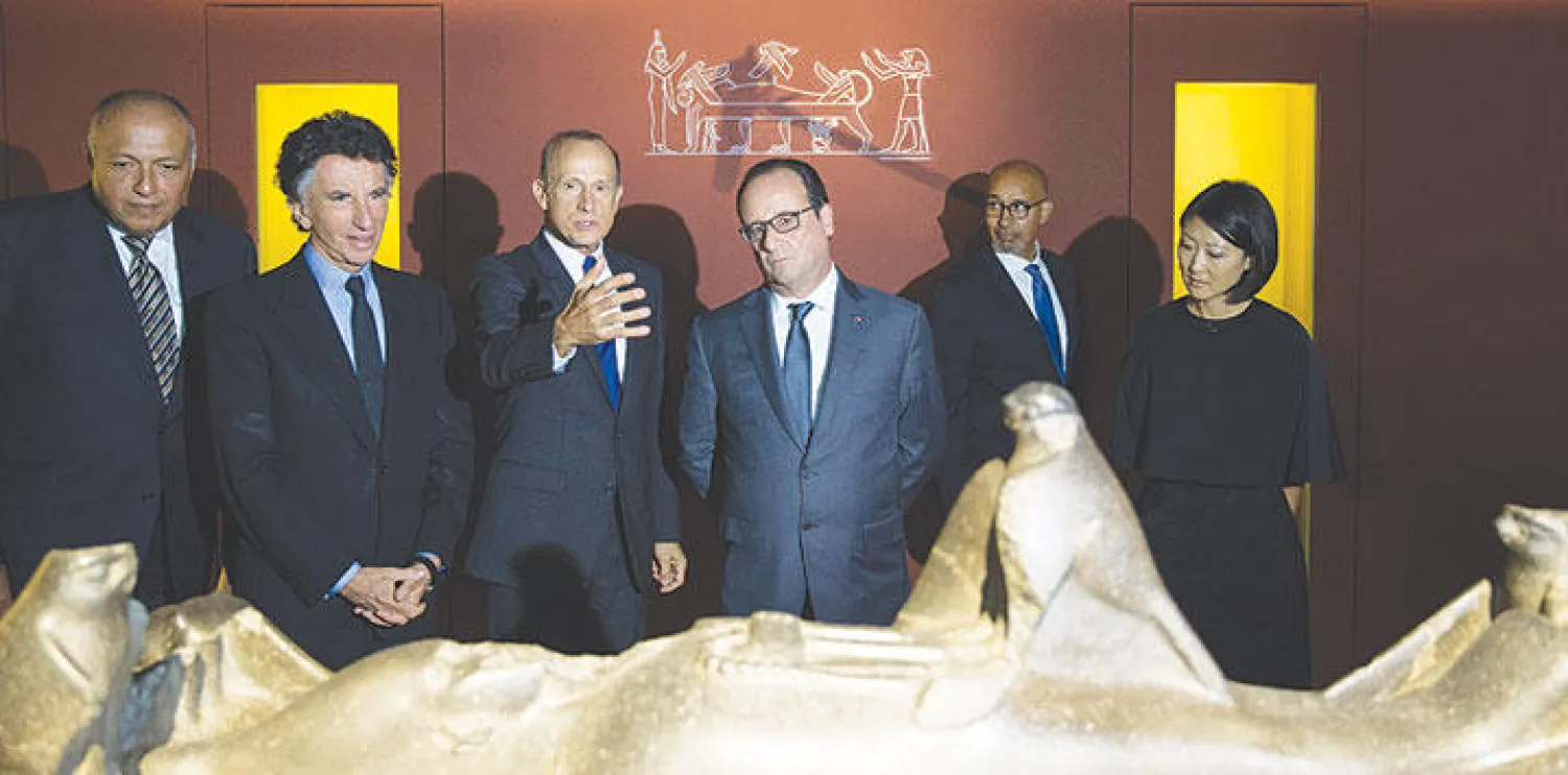 الرئيس الفرنسي فرنسوا هولاند يتوسط وزير الخارجية المصري سامح شكري ورئيس معهد العالم العربي جاك لانغ في افتتاح معرض «أوزيريس: أسرار مصر الغارقة» في باريس أمس (أ.ب)