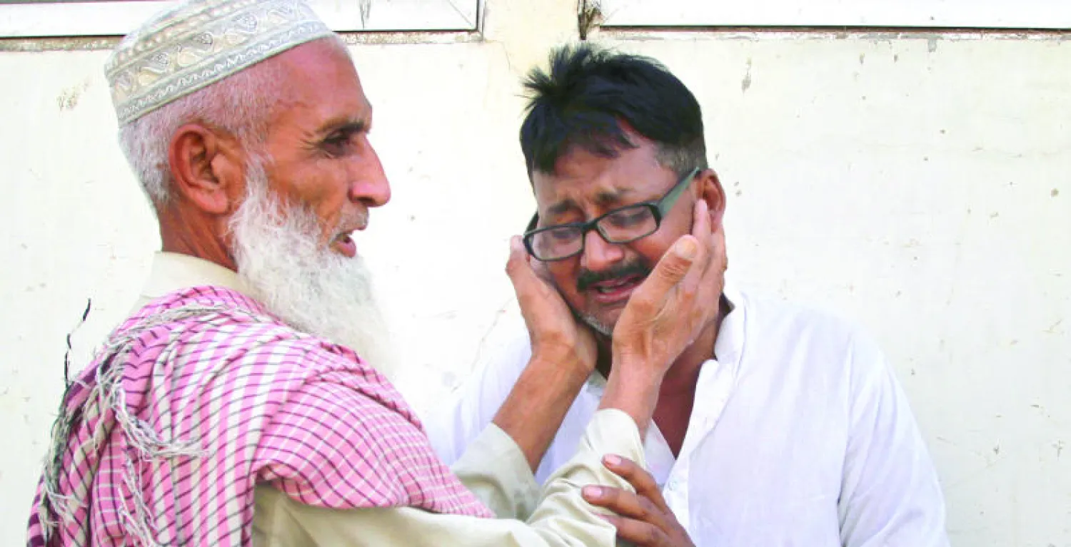 رجل يواسي أحد أقارب الصحافي أفتاب علم الذي قتله مجهولون في كراتشي أول من أمس (أ.ب)