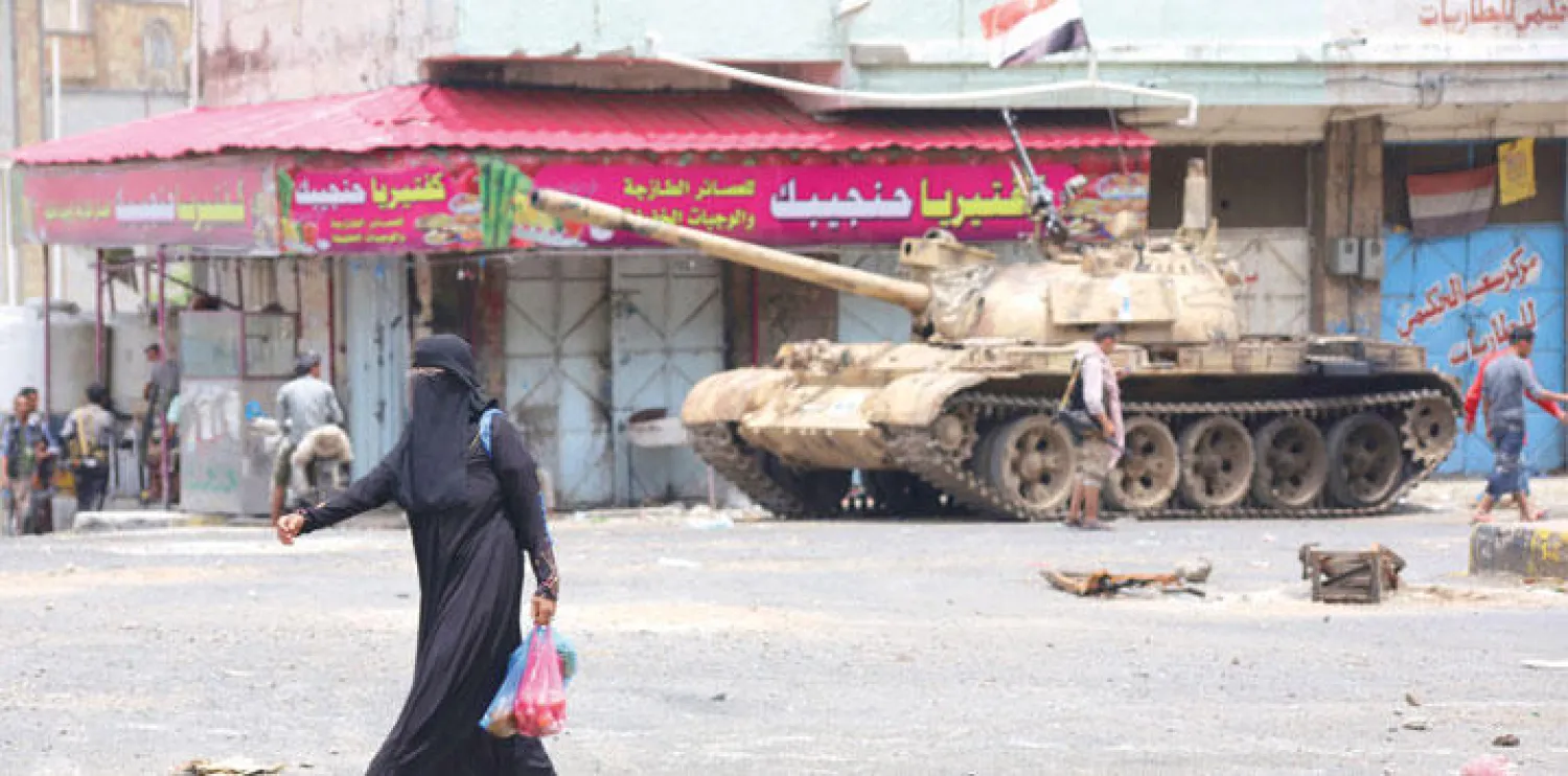 يمنية تمرّ أمام دبابة تابعة لمقاتلين موالين للشرعية في تعز أمس (أ.ف.ب)