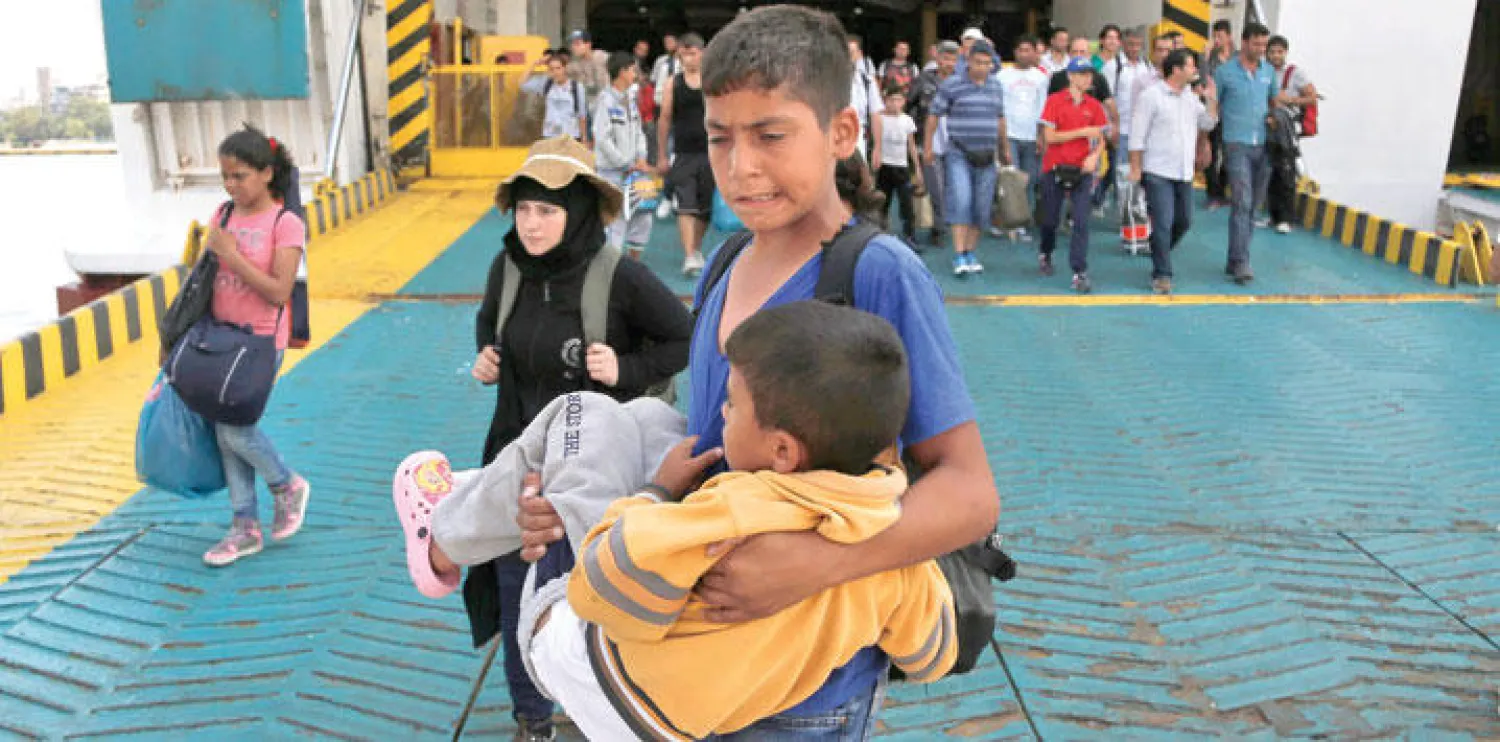 مهاجرون أغلبهم سوريون لدى وصولهم الى جزيرة بيراكوس اليونانية أمس (إ ب أ)