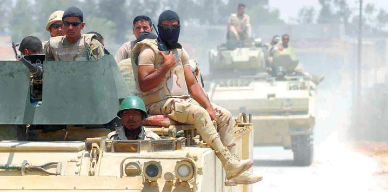 عناصر من الجيش المصري على مدرعة حربية قرب مدينة الشيخ زويد شمال سيناء (إ.ب.أ)