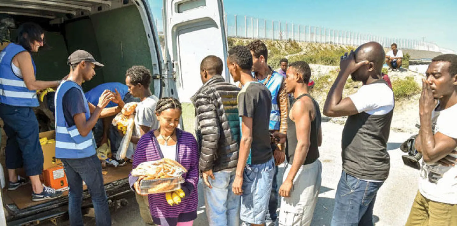 منظمة حقوقية توزع المعونات الغذائية على اللاجئين القابعين في كاليه شمال فرنسا (أ.ف.ب)