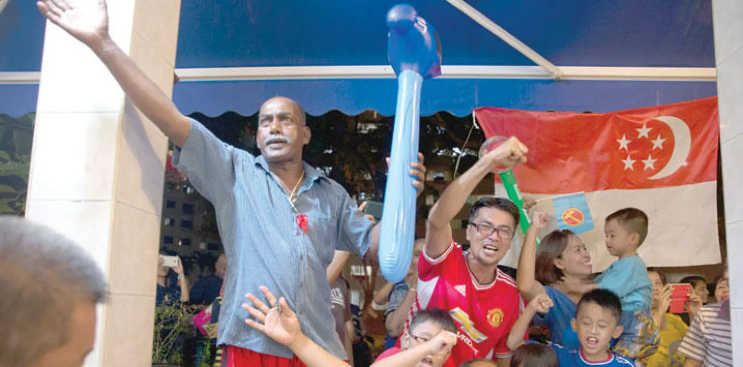 مؤيدون لحزب العمل الشعبي الحاكم ينتظرون في أحد مقاهي سنغافورة لحظة الإعلان عن فوز الحزب بالانتخابات العامة (أ.ب)