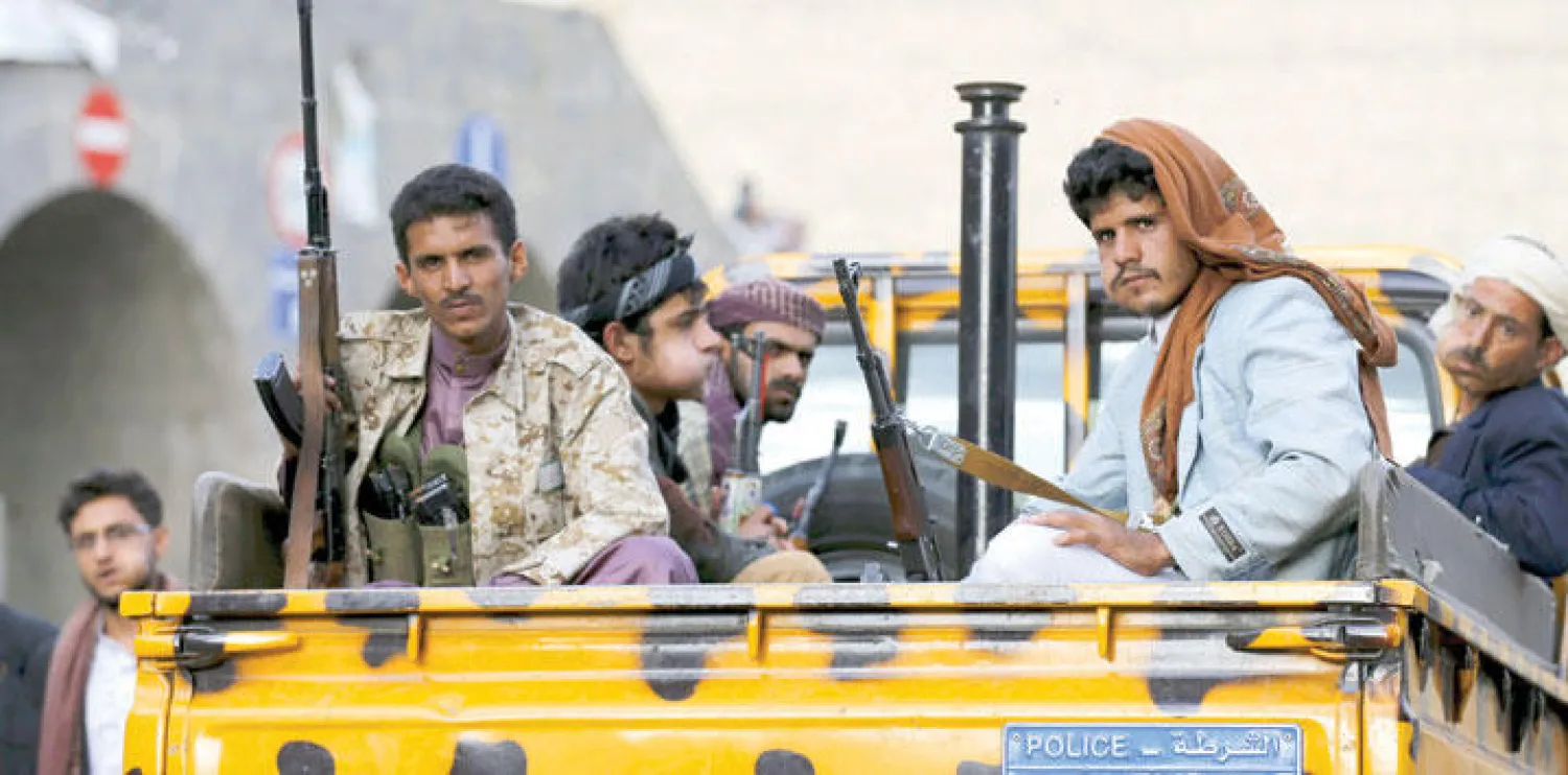 مقاتلون موالون للحوثي على متن سيارة شرطة في صنعاء (رويترز)