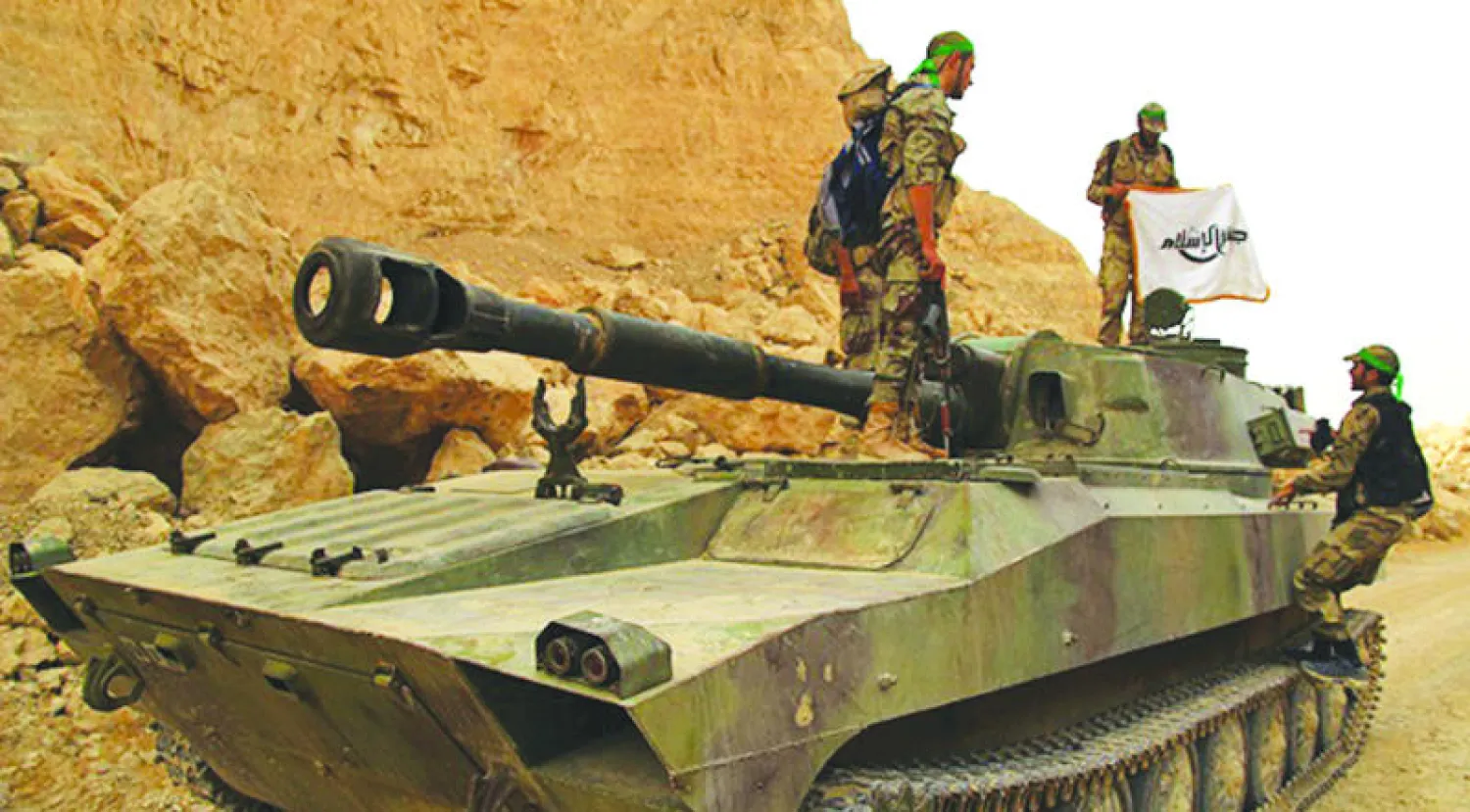 «جيش الإسلام» يعلن السيطرة على حواجز بريف دمشق ويرفع رايته على دبابة غنمها من النظام (الأناضول)