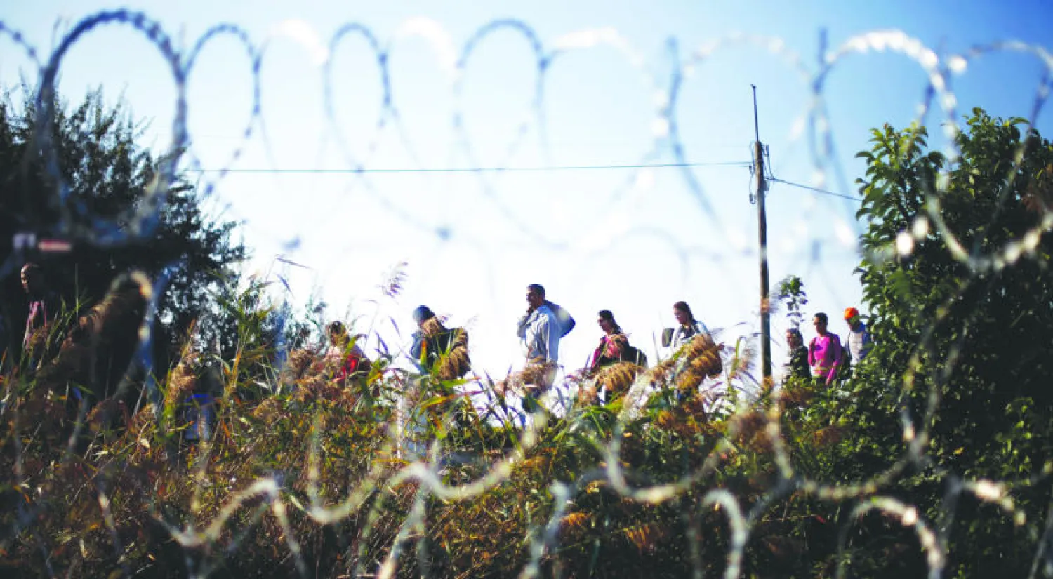 مهاجرون يصلون إلى الحدود الصربية - المجرية بالقرب من مدينة روزكي، جنوب المجر، أمس (أ.ب)