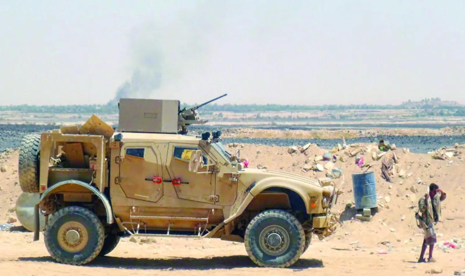 جندي يمني يسير أمام عربة عسكرية في منطقة سرواح بمحافظة مأرب أمس (أ.ف.ب)