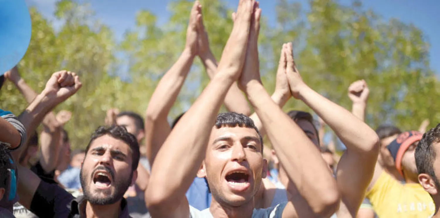 لاجئون معظمهم سوريون يتظاهرون بالقرب من مدينة إدرنه التركية لمطالبة السلطات بالسماح لهم بعبور الحدود إلى اليونان أمس (أ.ب)