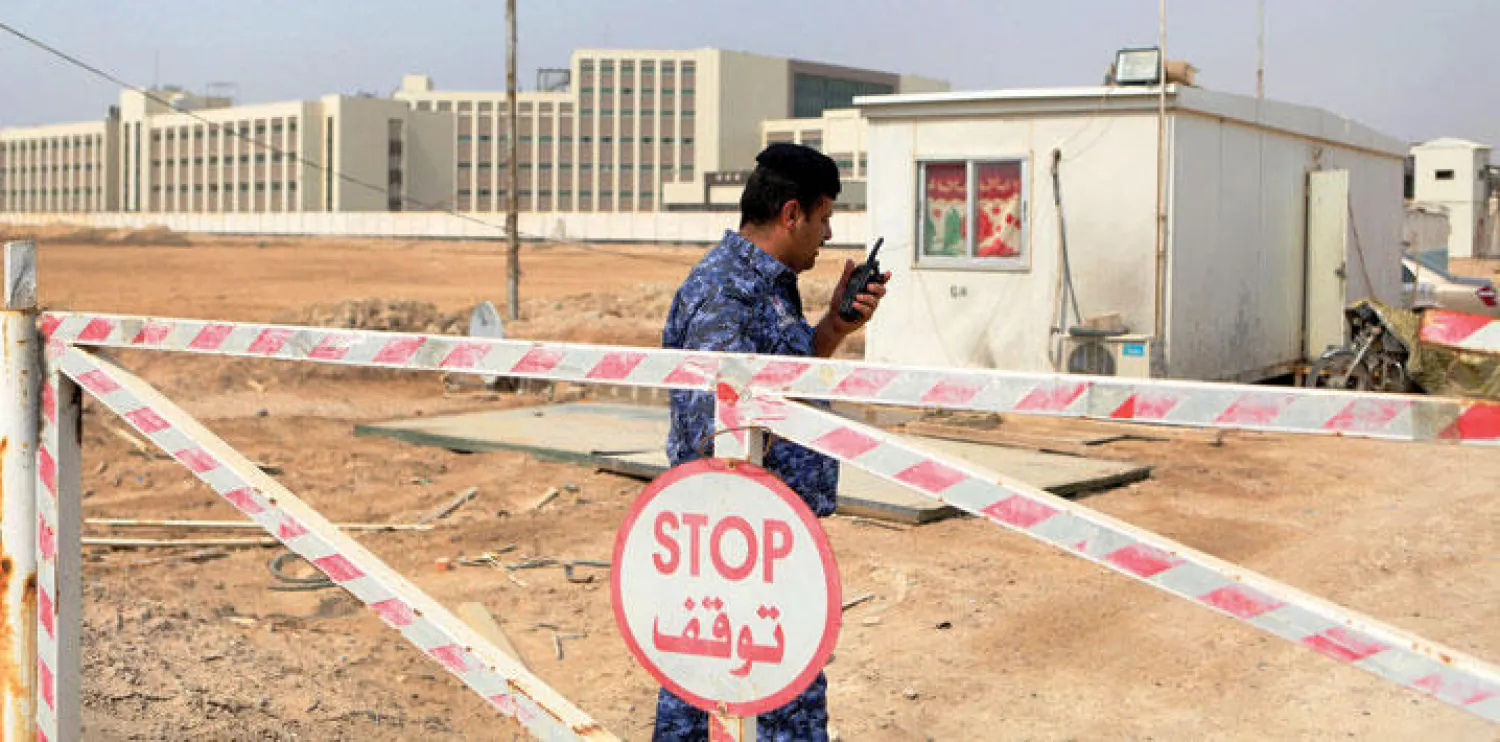 رجل شرطة عراقي يحرس مدخل مستشفى حيث يرقد العاملين التركيين المفرج عنهما (أ.ب)