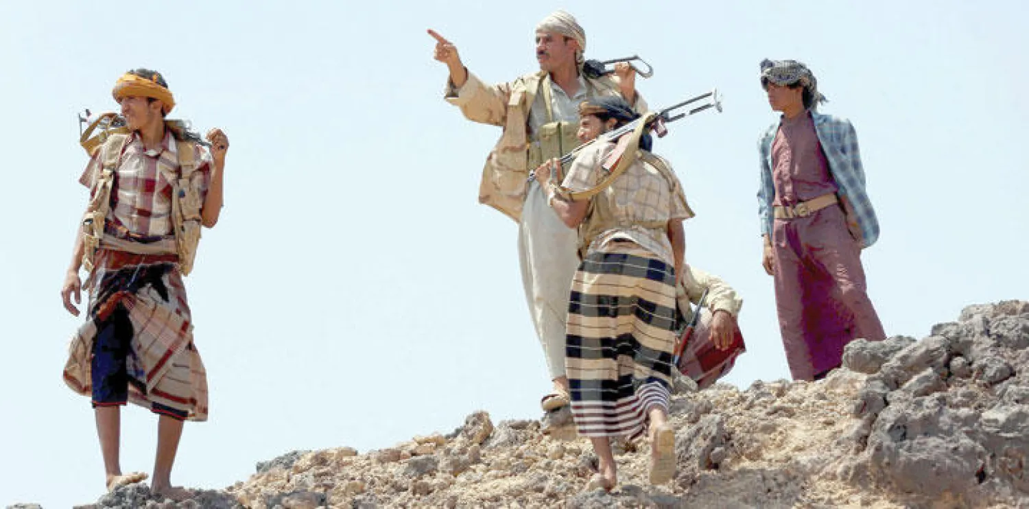 رجال قبائل موالون للحكومة الشرعية في اليمن يقفون على قمة تل بخط المواجهة في مأرب ( رويترز)