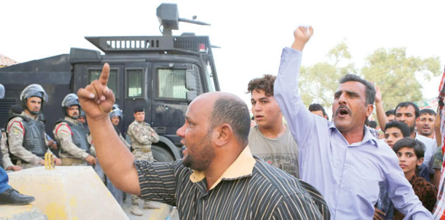 شرطة مكافحة الشغب العراقية تمنع متظاهرين من الاقتراب من مبنى مجلس المحافظة في البصرة أول من أمس (أ.ب)