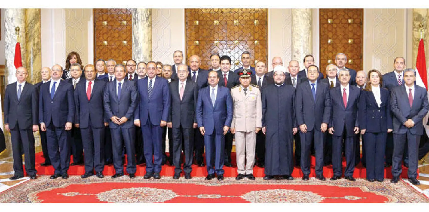 الوزراء الجدد مع الرئيس المصري بعد أداء اليمين الدستورية في القاهرة أمس (إ.ب.أ)