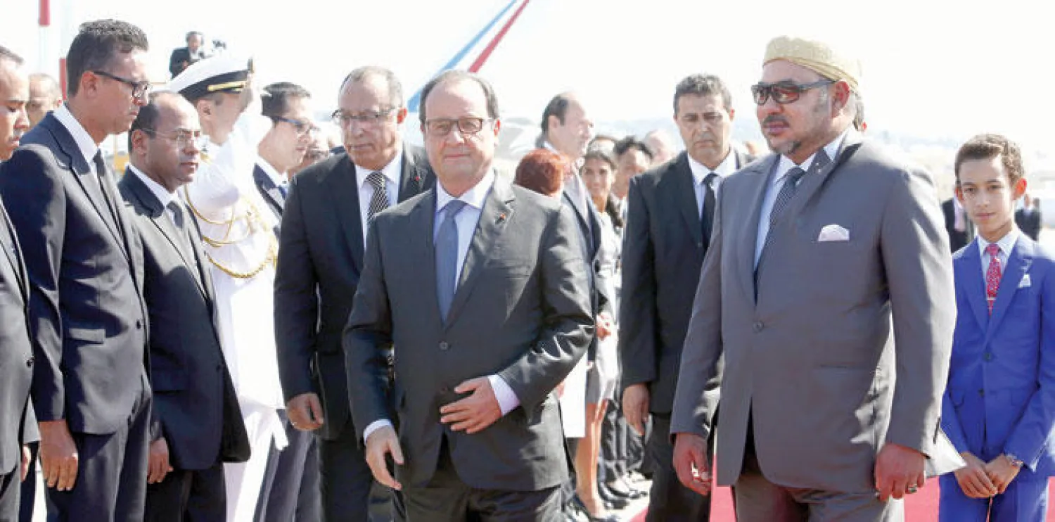 العاهل المغربي الملك محمد السادس خلال استقباله الرئيس الفرنسي فرنسوا هولاند في مطار طنجة أمس (أ.ب)