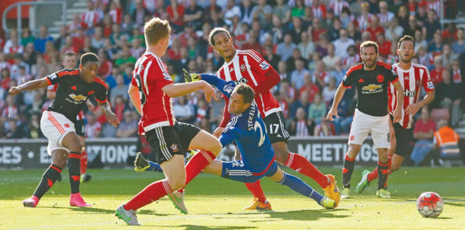 مارسيال مهاجم يونايتد (يسار) يسدد نحو مرمى ساوثهامبتون محرزا هدفه الأول (رويترز)