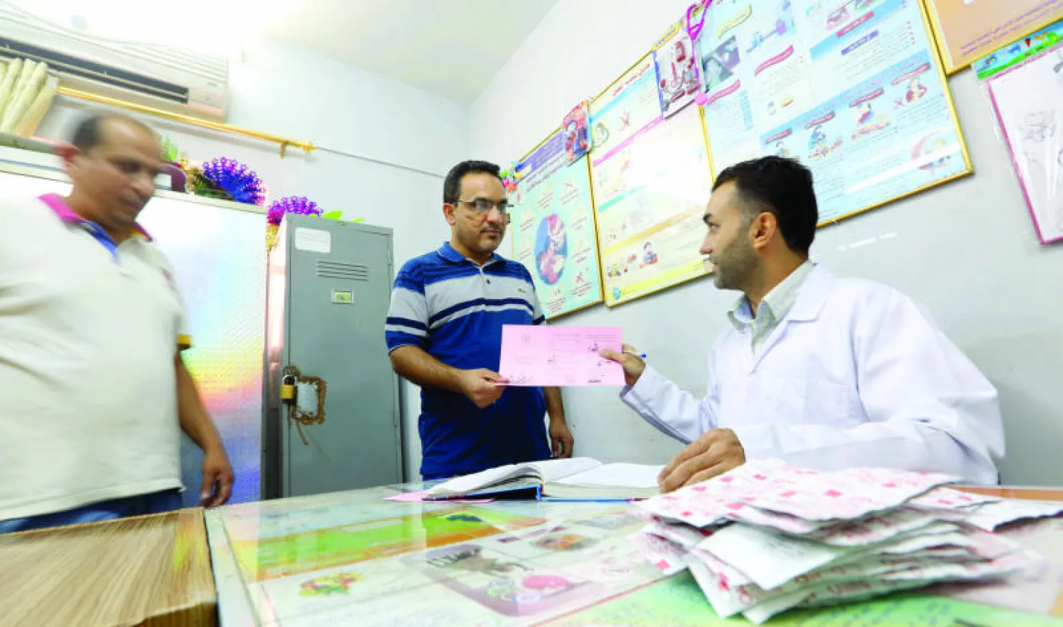 طبيب عراقي يوزع منشورا صحيا فيه إرشادات لكيفية تجنب الكوليرا في بغداد (أ.ب)