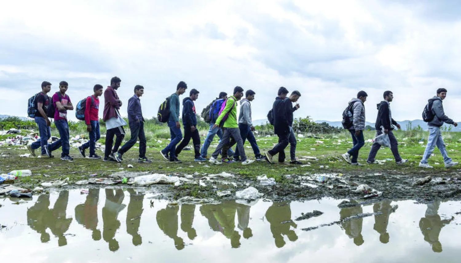 لاجئون ومهاجرون يصلون إلى مخيم تسجيل قرب بلدة غيفيغليا، بعد أن اجتازوا الحدود المقدونية - اليونانية أمس (أ.ف.ب)