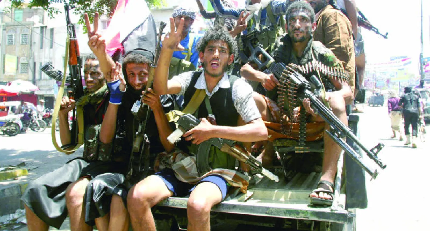 يمنيون موالون للحكومة بأسلحتهم أثناء مظاهرة تأييد للرئيس هادي في تعز أمس (رويترز)