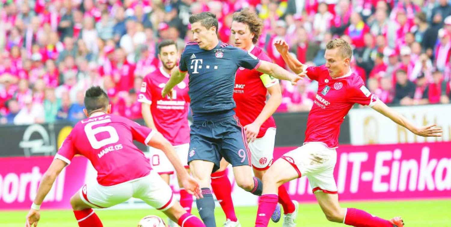 غابة من السيقان تحيط بهداف بايرن روبرت ليفاندوفسكي (أ.ب)