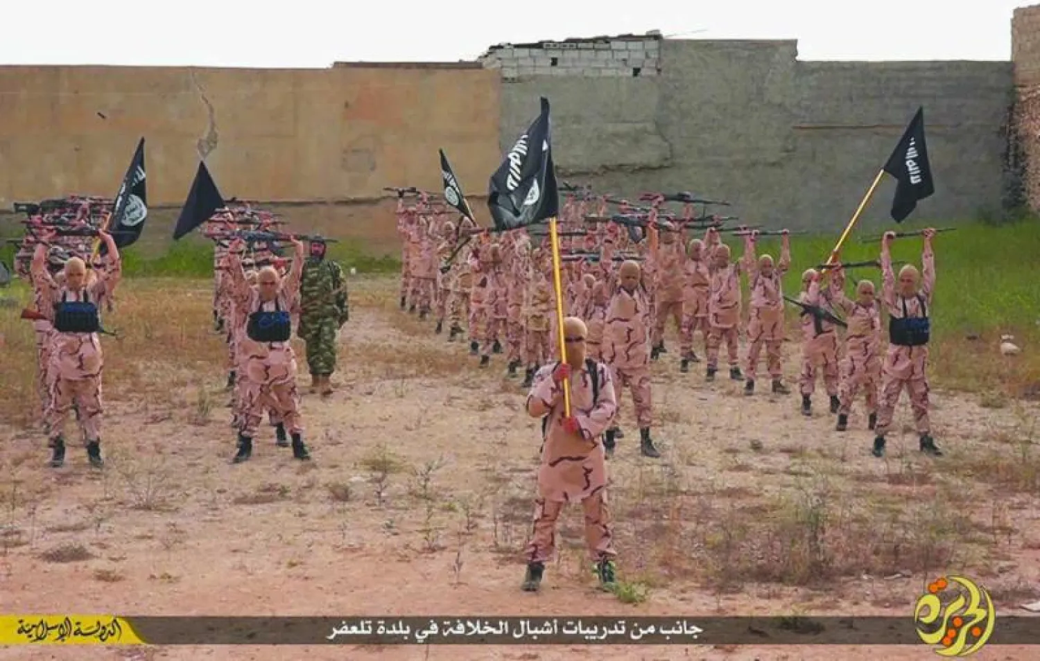 لقطة من فيديو تظهر فتية ضمن مجموعات «الأشبال» التابعة لتنظيم داعش خلال تمرين في تلعفر بشمال العراق (أ.ب)