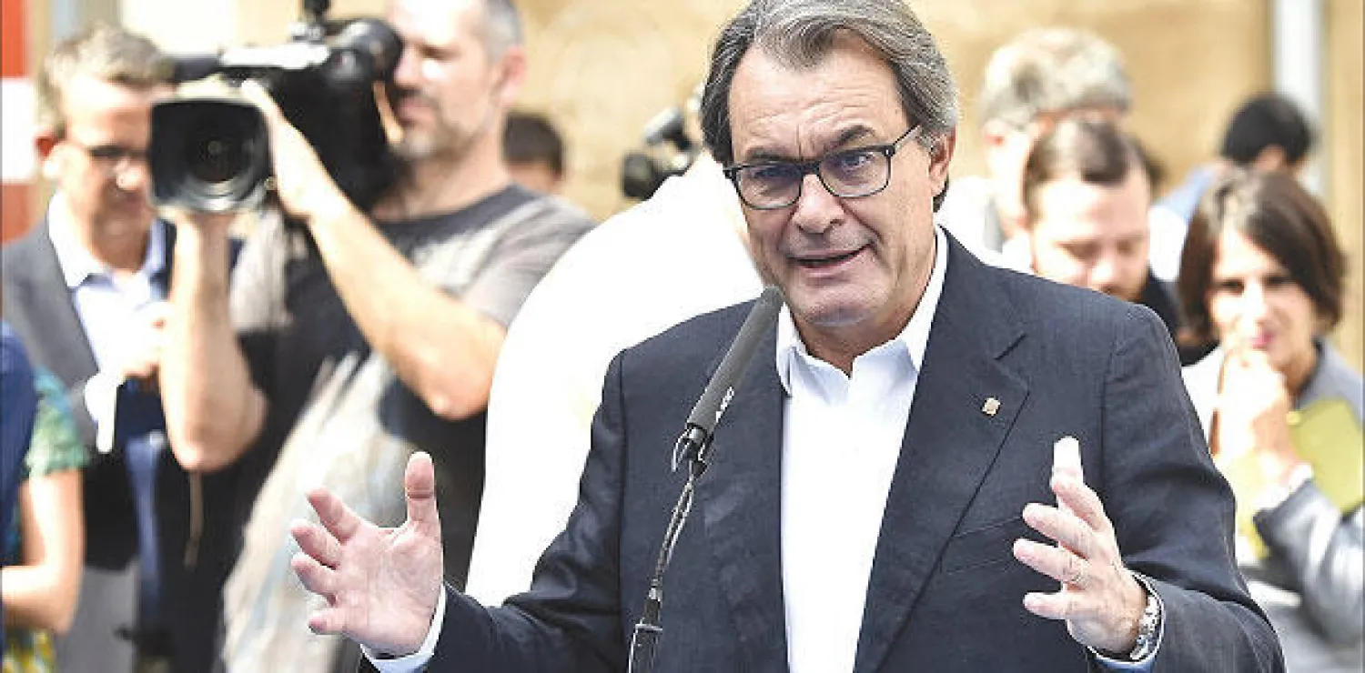 الرئيس الكتالوني المنتهية ولايته أرتور ماس يلقي خطابًا في مؤتمر صحافي خارج إحدى محطات الاقتراع أمس (أ.ف.ب)