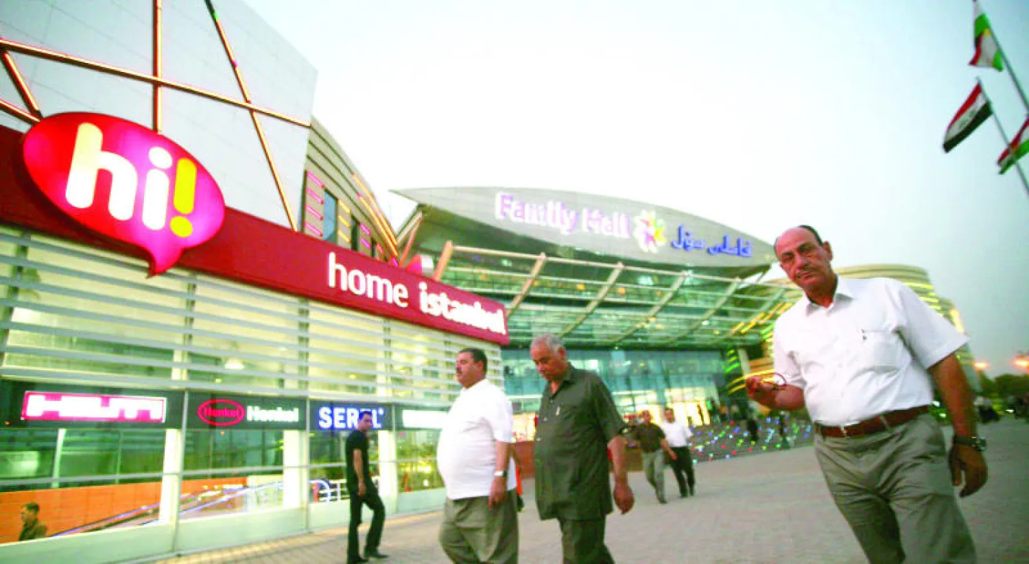 عراقيون يتجولون خارج مركز تجاري في مدينة اربيل (أ.ف.ب)