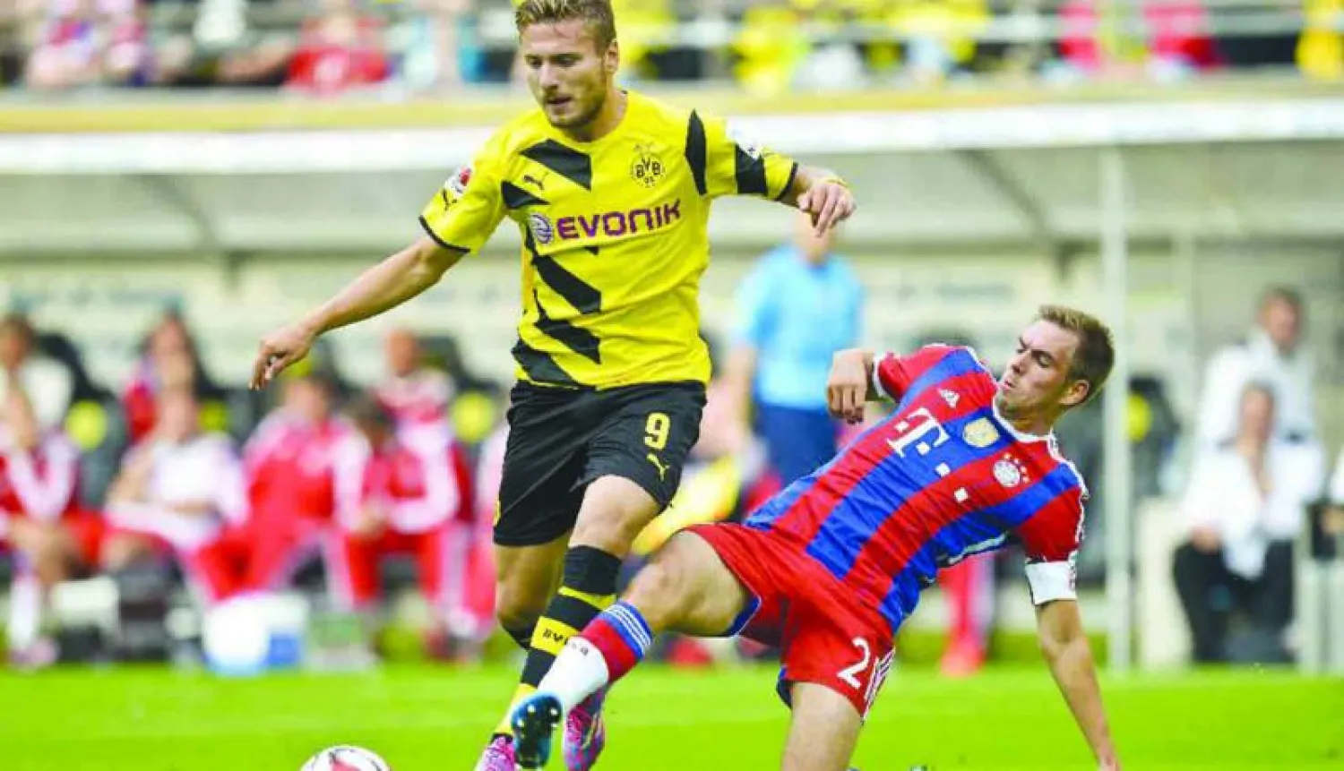 صراع على الكرة بين أمبولي لاعب دورتموند (يسار) ولام قائد بايرن ميونيخ في لقاء سابق (أ.ب)