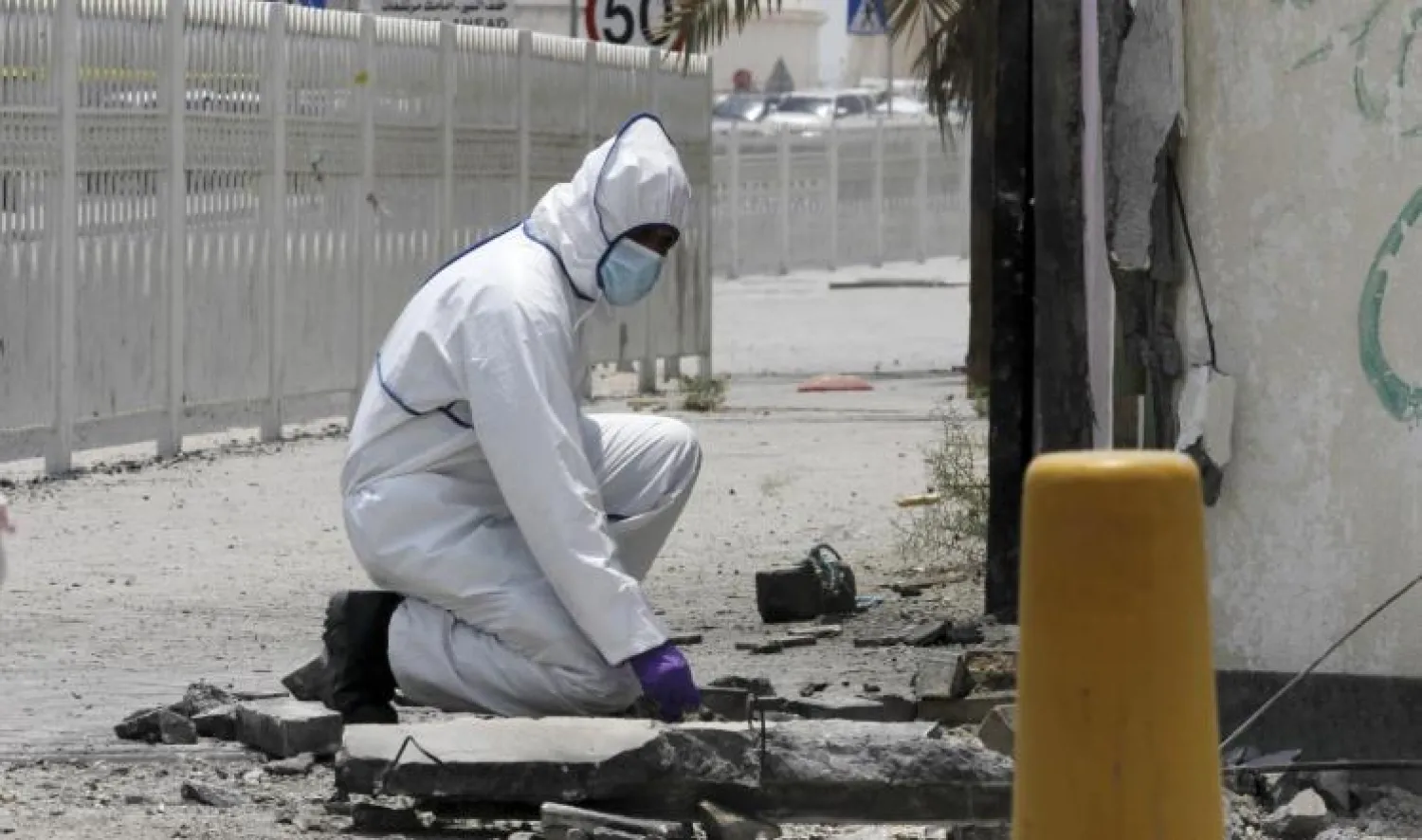 رجل أمن بحريني يعاين موقع انفجار قنبلة في حادثة "سترة" يوليو (تموز) الماضي (رويترز)