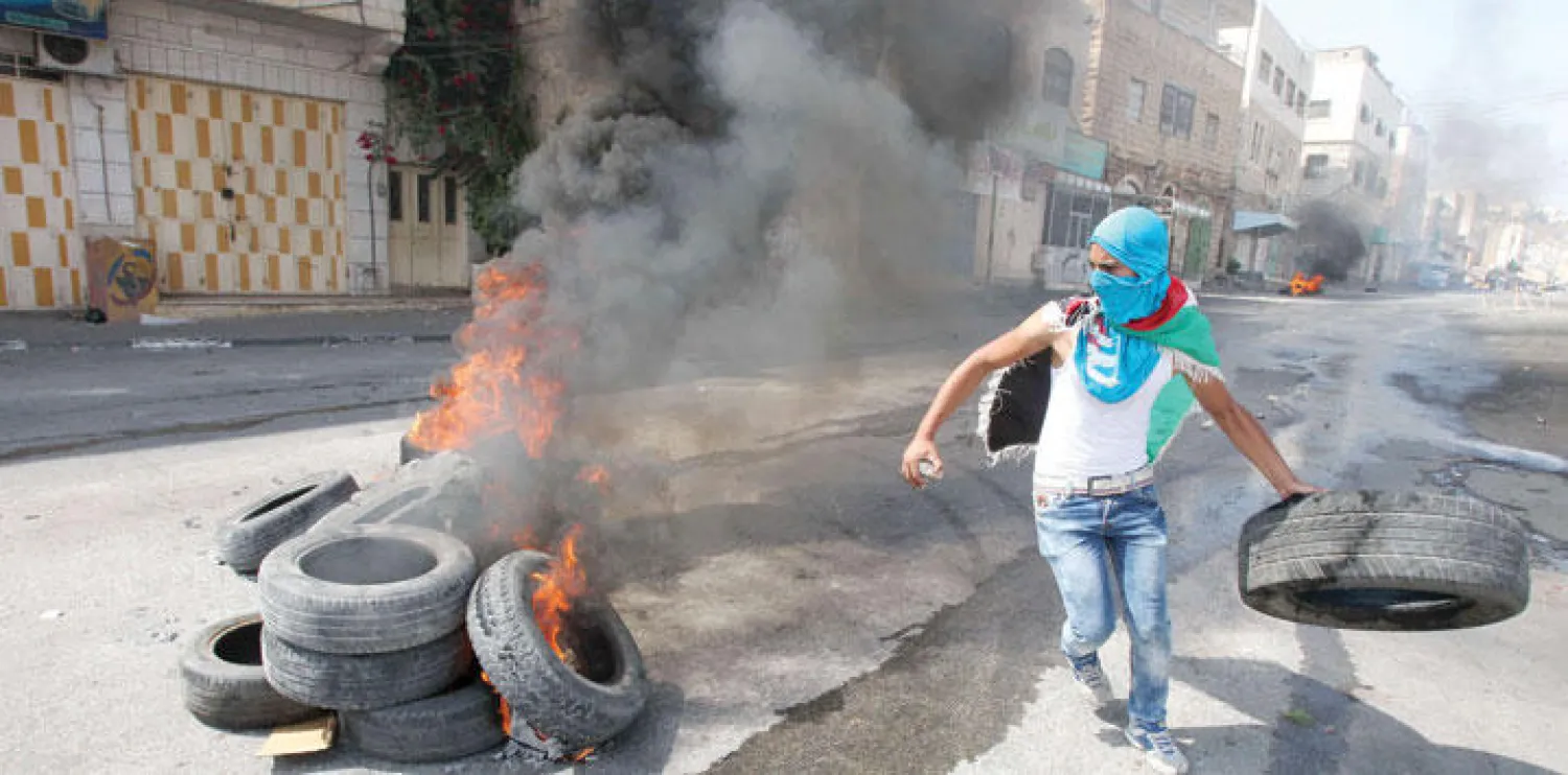 شاب فلسطيني يشارك في الاحتجاجات التي خرجت إلى شوارع الضفة الغربية ردًا على اعتداءات المستوطنين أمس (أ.ف.ب)