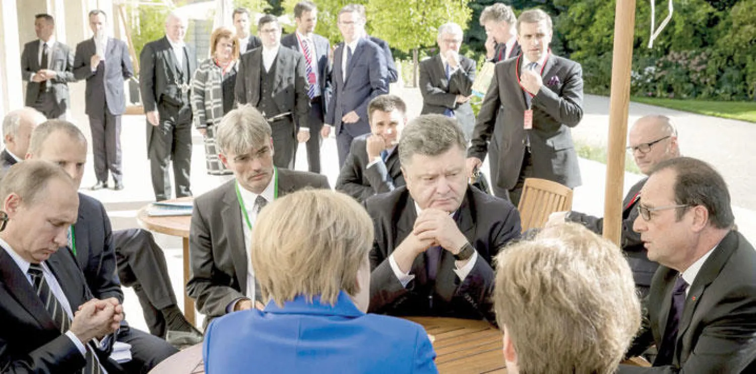 الرئيس الفرنسي فرنسوا هولاند ونظيراه الأوكراني بيترو بوروشينكو والروسي فلاديمير بوتين والمستشارة الألمانية أنجيلا ميركل لدى اجتماعهم في باريس لبحث الأزمتين السورية والأوكرانية أمس (أ.ب)