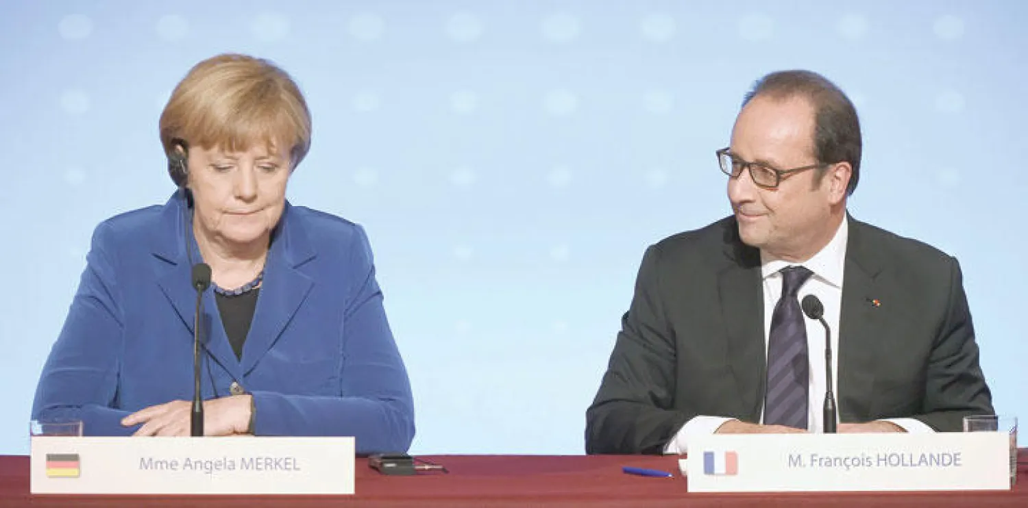 المستشارة الألمانية أنجيلا ميركل والرئيس الفرنسي فرنسوا هولاند خلال لقائهما مساء أول من أمس في باريس لمناقشة الأزمة الأوكرانية (أ.ف.ب)