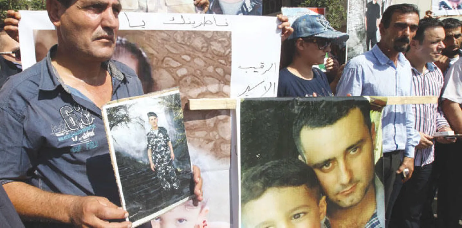 أقرباء جنود مختطفين في لبنان يحملون صورهم خلال وقفة احتجاج في جنوب بيروت أمس (أ.ف.ب)