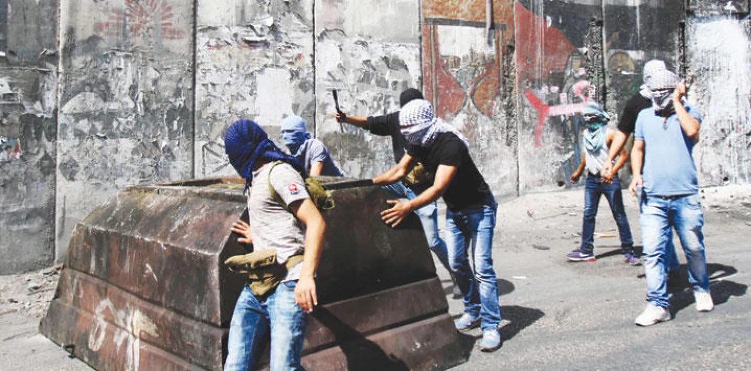 فلسطينيون خلال مواجهات مع القوات الإسرائيلية في القدس أمس (أ.ف.ب)