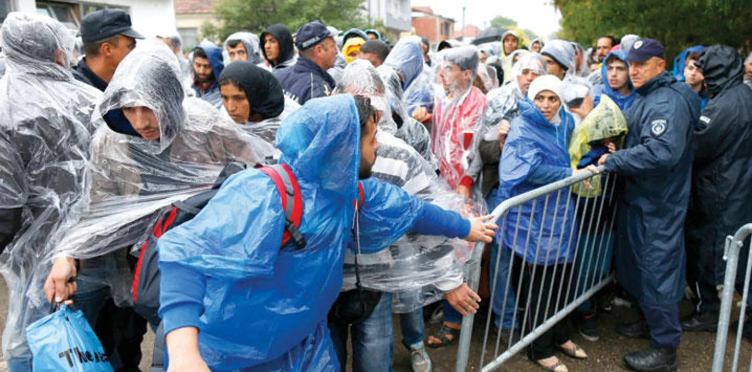 مهاجرون ينتظرون دورهم خارج أحد مراكز التسجيل في مدينة بريسيفوا جنوب صربيا أمس (أ.ب)