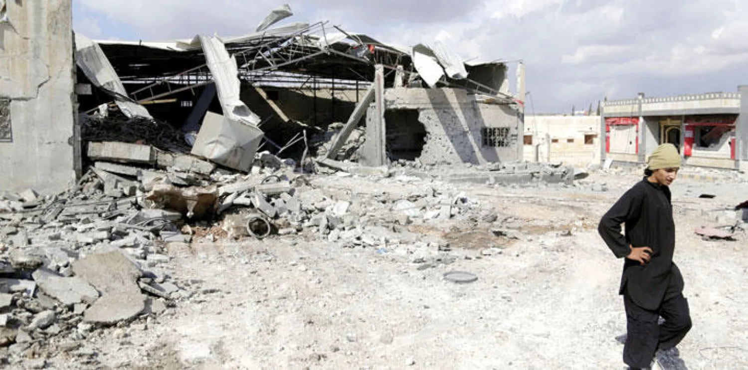 سوري أمام أنقاض مبنى استهدفه القصف الروسي أمس في بلدة بابيلا جنوب إدلب شمال غربي سوريا (رويترز)