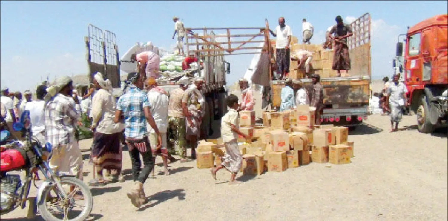 سكان يتجمعون للحصول على مساعدات غذائية في قرية سقاية على الجبهة الأمامية من مضيق باب المندب (رويترز)