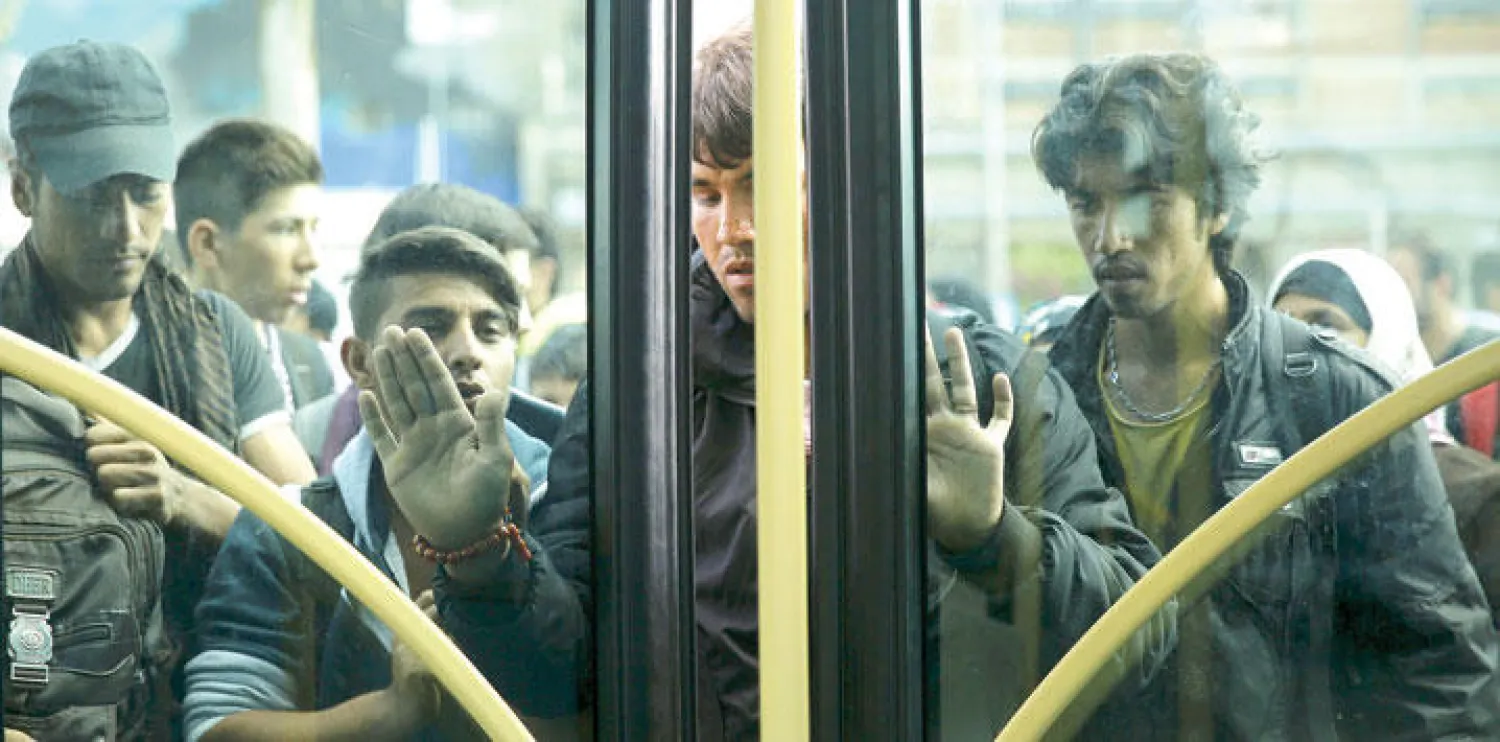 مهاجرون ولاجئون يركبون على متن عبارة باتجاه ميناء بيرايوس بالقرب من العاصمة اليونانية أثينا أمس (رويترز)