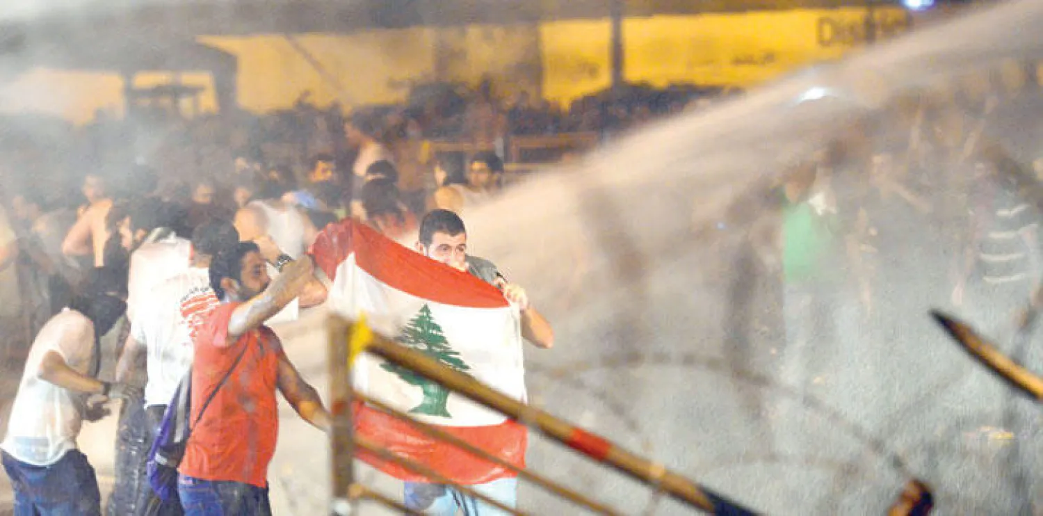 قوات الأمن في لبنان تواجه متظاهرين حاولوا إزالة الأسلاك التي تغلق طريقا يؤدي إلى البرلمان في بيروت (إ.ب.أ)