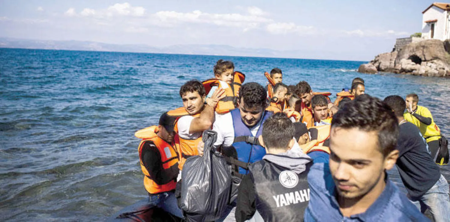 مهاجرون لدى وصولهم أمس إلى جزيرة ليسبوس اليونانية (أ.ف.ب)