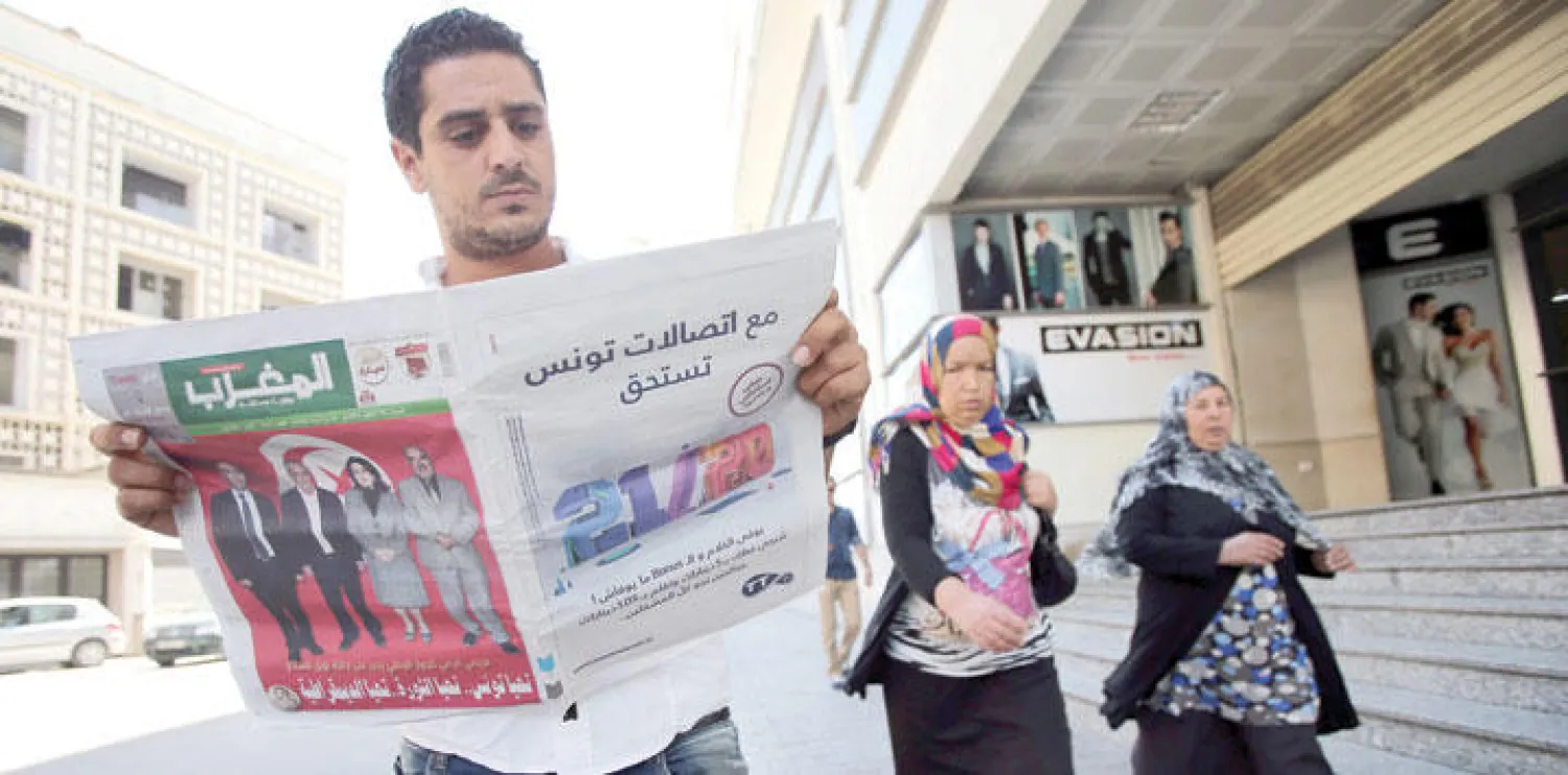 تونسي يقرأ في صحيفة محلية أمس خبر فوز رباعي الحوار الوطني بجائزة نوبل للسلام أول من أمس (إ.ب.أ)
