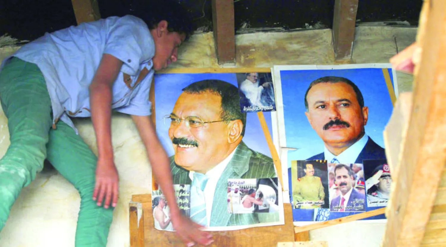 فتى يمني أمام صور لصالح داخل محل تجاري في صنعاء أول من أمس (إ.ب.أ)