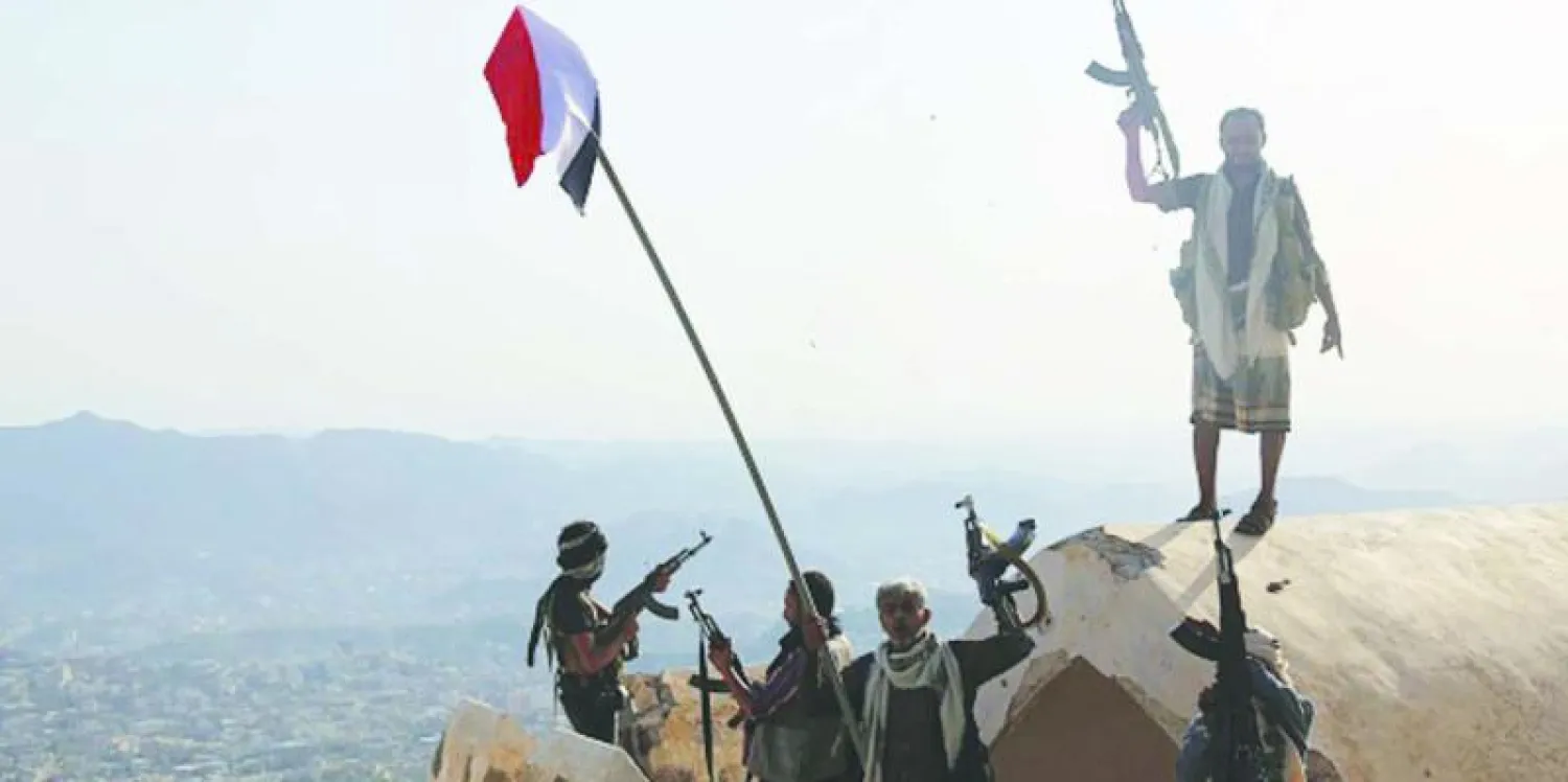 مقاتلون موالون للشرعية والتحالف العربي يرفعون العلم اليمني على قمة قلعة القاهرة، الواقعة في السفح الشمالي لجبل صبر بتعز (غيتي)