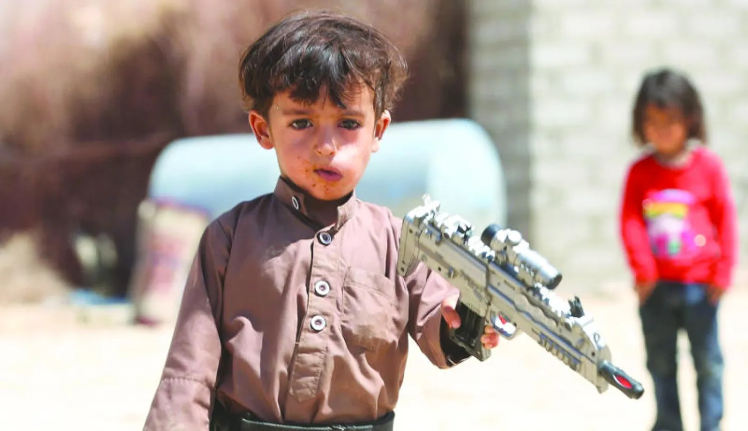 طفل يمني يحمل بندقية لعبة في مخيم للنازحين الذين أجبروا على مغادرة منازلهم بسبب العنف الحوثي في مأرب المحررة (رويترز)