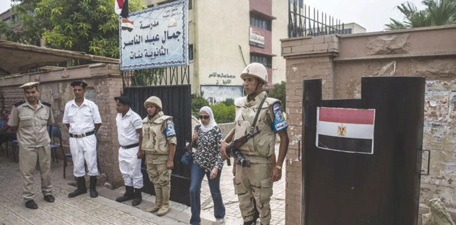 عسكريون يحرسون خارج مركز اقتراع في حي الدقي بالقاهرة أمس (أ.ف.ب)