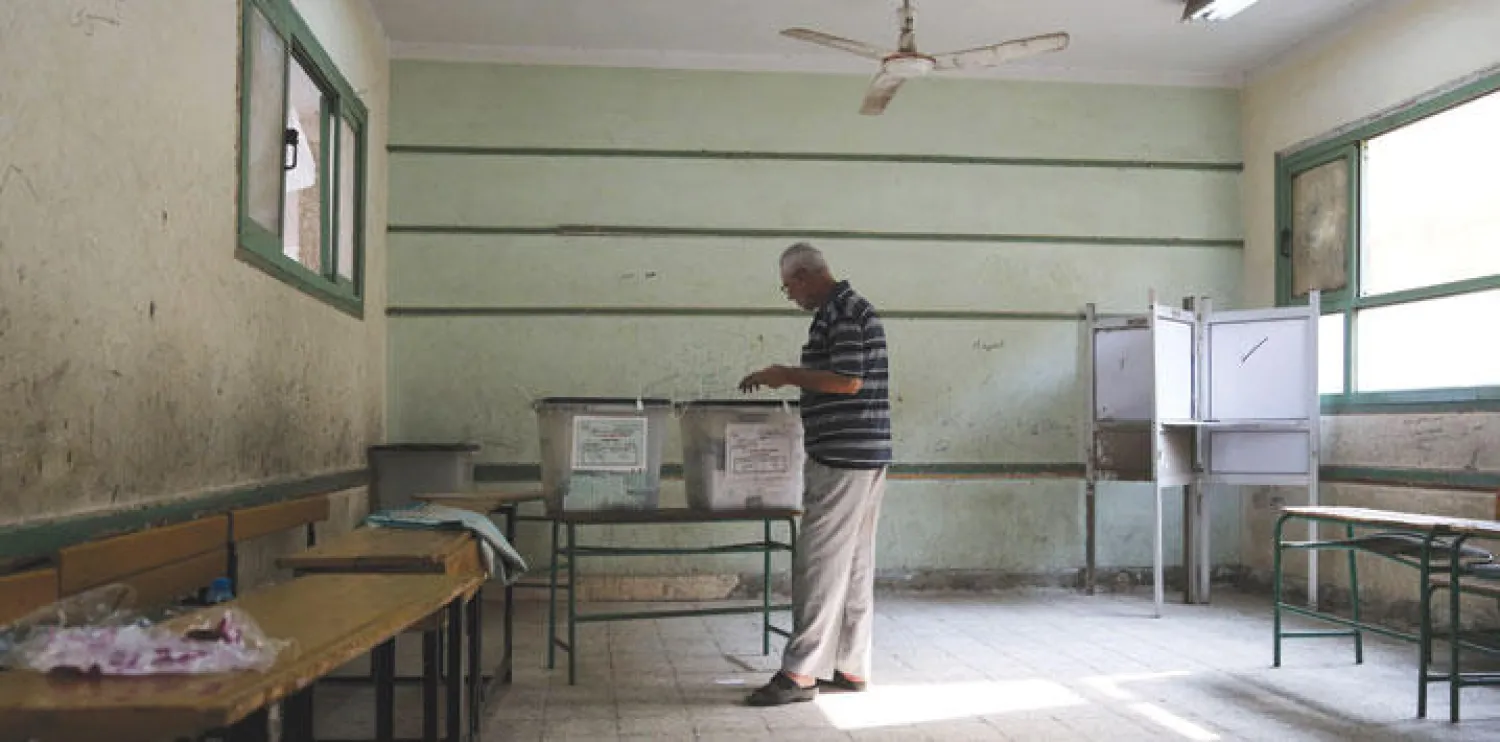 مواطن مصري يدلي بصوته في لجنة انتخابية تعاني من قلة الحضور في محافظة الجيزة أمس (رويترز)