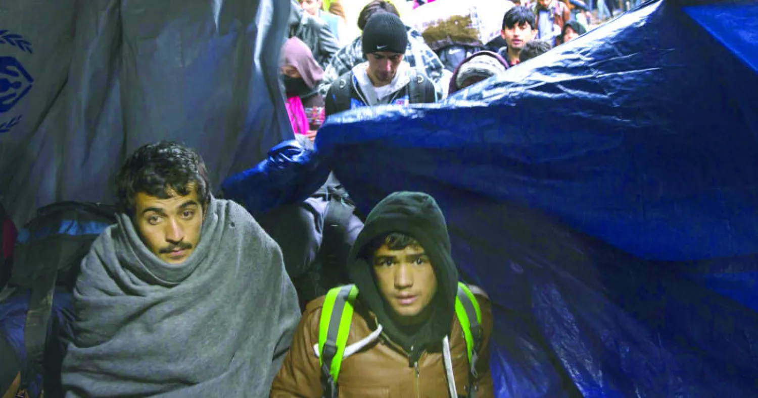 مهاجرون يحتمون تحت خيمة بالقرب من قرية بيركاسوفو الصربية في انتظار عبور الحدود مع كرواتيا أمس (رويترز)