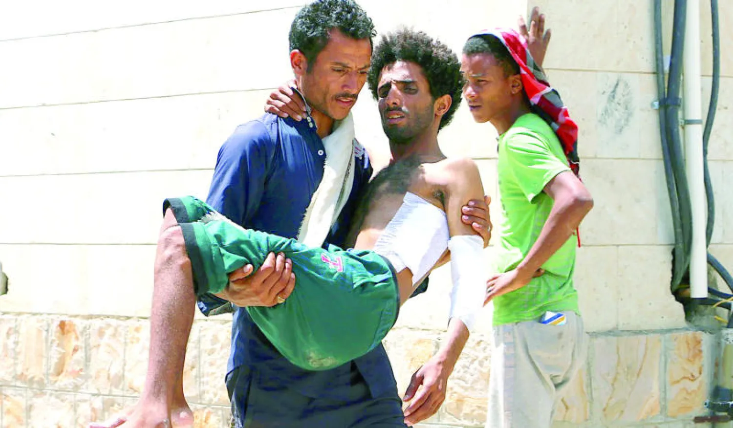 يمني يحمل آخر جريحا إثر هجمات للحوثيين بالصواريخ على منطقة سكنية في مدينة تعز ({غيتي})