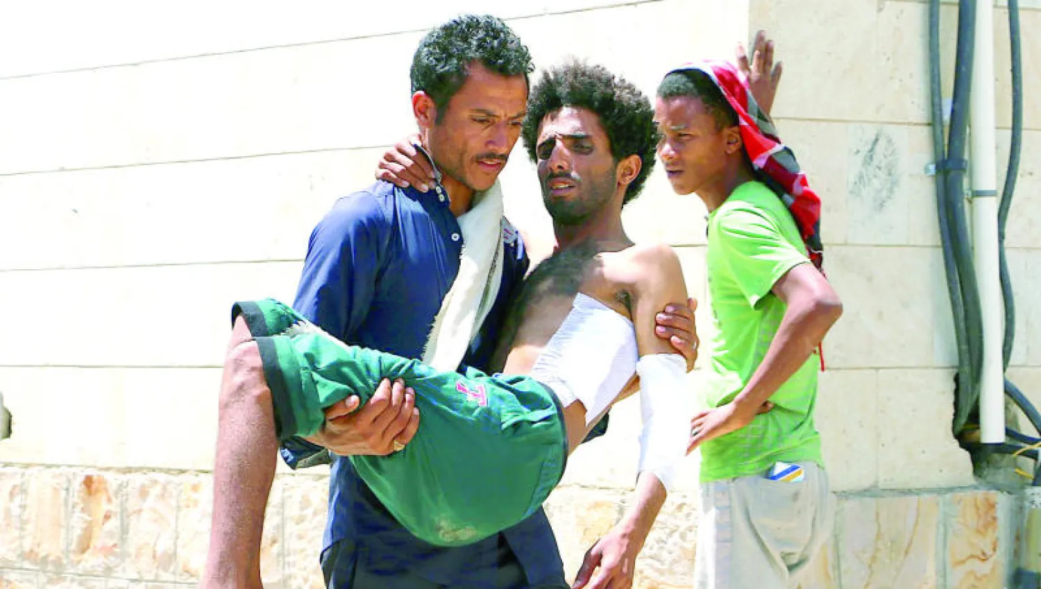 يمني يحمل آخر جريحا إثر هجمات للحوثيين بالصواريخ على منطقة سكنية في مدينة تعز ({غيتي})