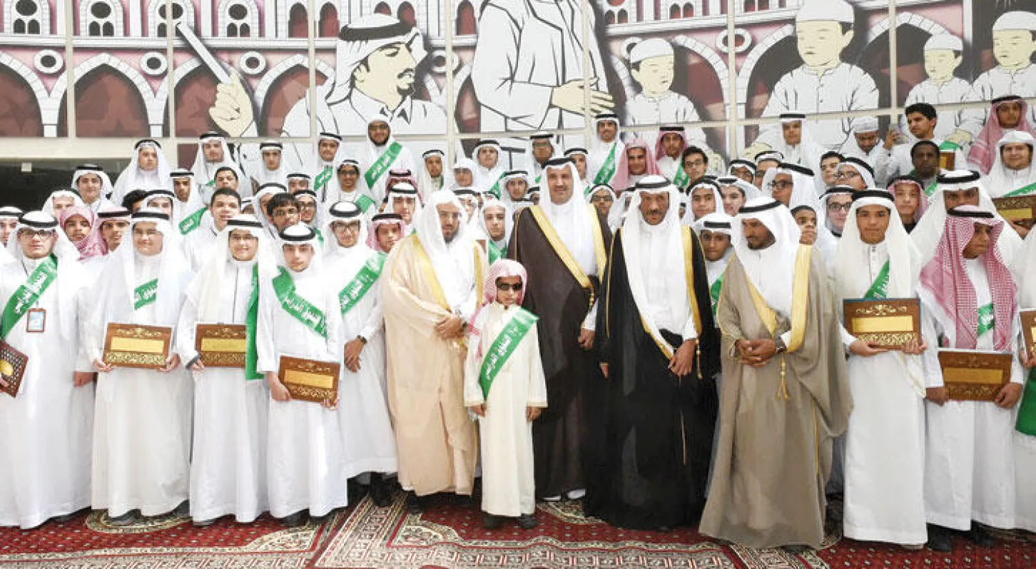 صورة تجمع الأمير فيصل بن سلمان مع عدد من مسؤولي وزارة التربية والطلاب المكرمين («الشرق الأوسط»)